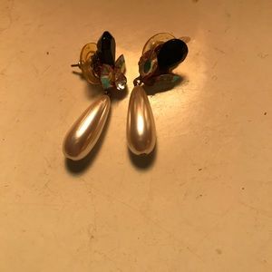 Pearl earrings and a sleeveless size 10/12 woman’s black dress